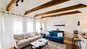 A living room with a beige sofa, a blue sofa, a coffee table, and a patterned rug. - Charming Three Bdrm Home on Quiet Street- Near U of M - Fully Fenced Yard- (Memphis)