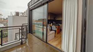 A modern apartment with a balcony, large sliding glass doors, and a view of the cityscape. - City Center Premium Apartment by Vacationy (Porto)