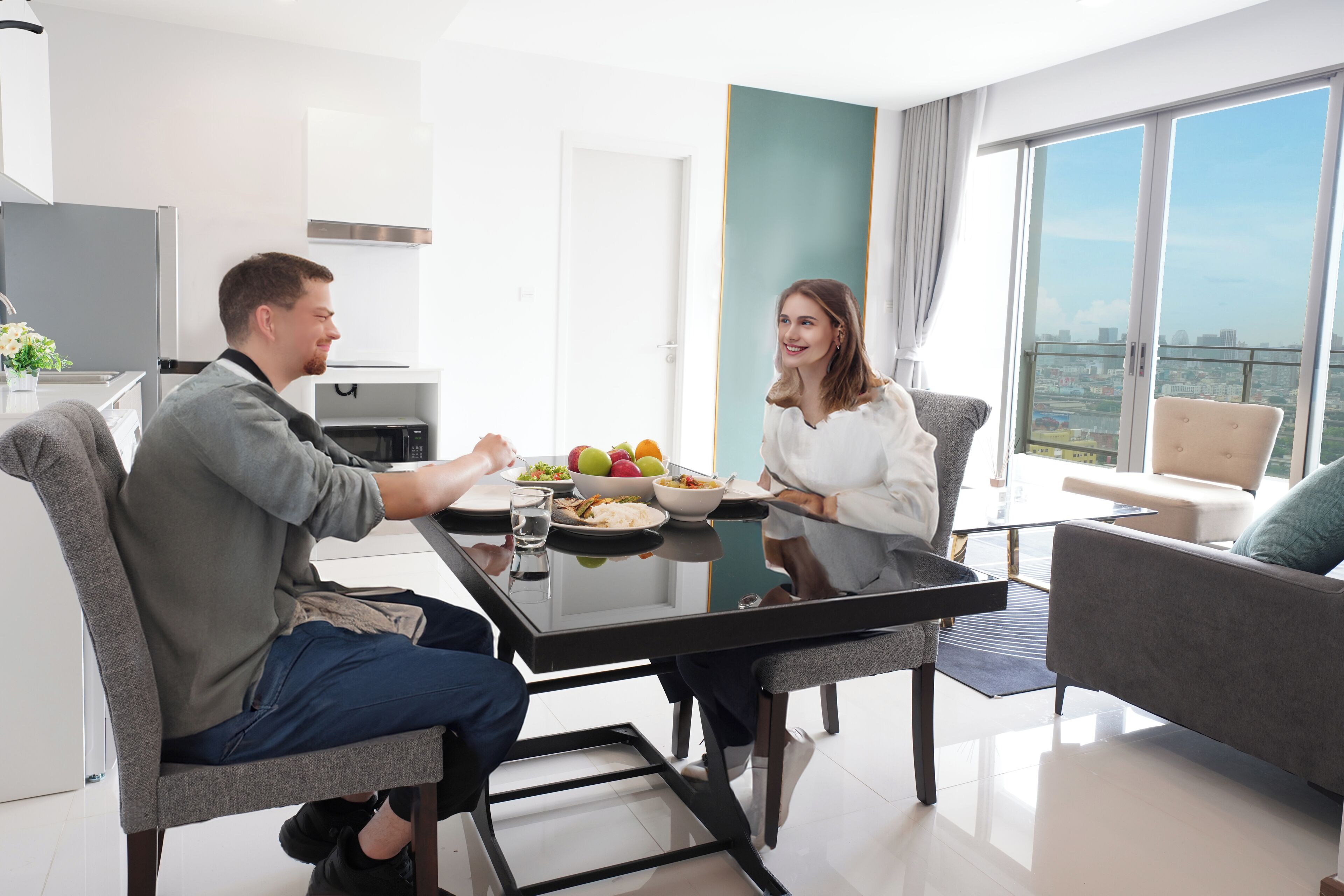 A modern dining area with a glass table, grey upholstered chairs, and a city view through large windows.