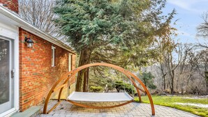 A brick house with a swing chair in the backyard. - Hudson Valley Hilltop Escape w/Hot Tub, 5private acres, near wine trail, orchard (Marlboro)
