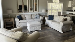 A living room with a sectional sofa, a chaise lounge, and a dining area with a table and chairs. - Quiet Beach Getaway (Myrtle Beach)