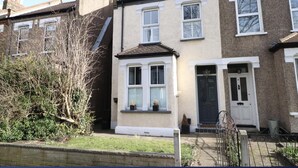 A row of terraced houses with a front garden, a tree, and a metal gate. - Inviting 3-bed House in Beckenham (Beckenham)