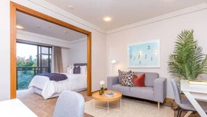 Une chambre d’hôtel moderne équipée d’un lit, d’un canapé, d’une table basse et d’un bureau.