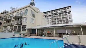 Un hôtel doté d’une piscine, d’une tour et d’un bâtiment avec des balcons.