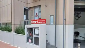 A building with a 'keyp-it' sign, a small kiosk, and a staircase leading to an entrance. - Sky Tower Views | 2 Bed 2 Bath CBD | Zodiak Stays (Auckland)