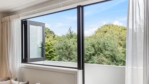 A room with a large window, a sofa, and curtains. - Convenient Modern 2-Bedroom Unit With Free Parking (Auckland)