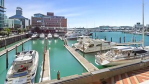A marina with boats docked, a modern building with a dome, and a clear blue sky. - Gorgeous 2BR in Wynyard Quarter by Zodiak Stays (Auckland)
