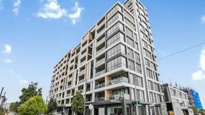 Un immeuble à plusieurs étages doté d’une architecture moderne, caractérisé par un mélange de façades en verre et en béton.