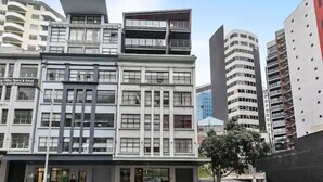Een meerhoog gebouw met een modern architectonisch ontwerp, met een combinatie van commerciële en woonruimtes.