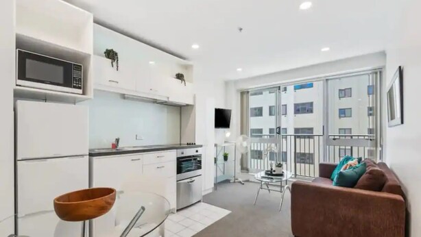 A modern apartment with a kitchen, dining area, and living room.