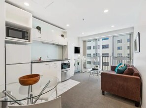 Ein modernes Apartment mit Küche, Essbereich und Wohnzimmer.