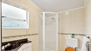 A bathroom with a shower, toilet, and sink. - Charming 3 Bedroom Home In Tranquil Rural Karaka (Karaka)