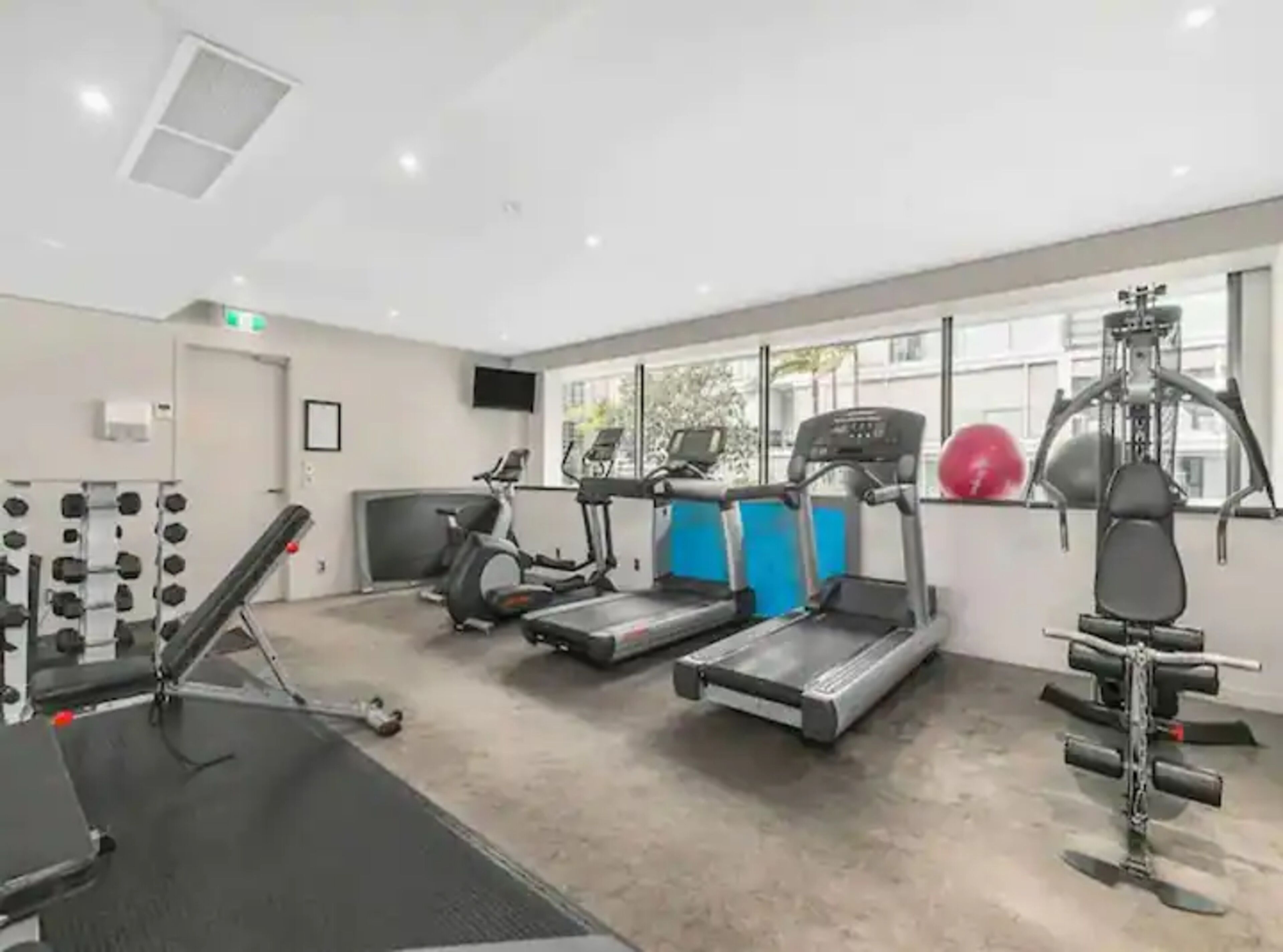 A gym with treadmills, elliptical machines, weightlifting equipment, and a rowing machine.