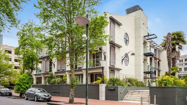 A modern building with a flat facade, large windows, and a gated entrance. - One-bedroom loft in Viaduct by Zodiak Stays (Auckland)