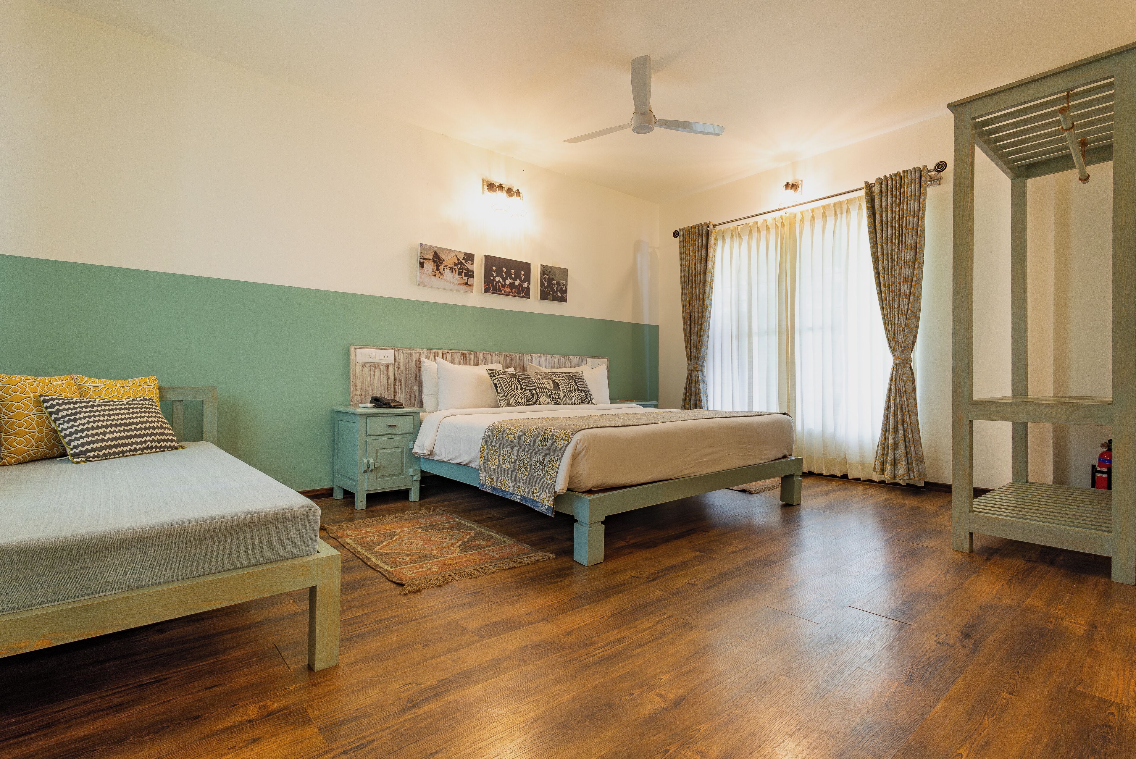 A bedroom with a bed, a nightstand, a wooden bench, and a ceiling fan.
