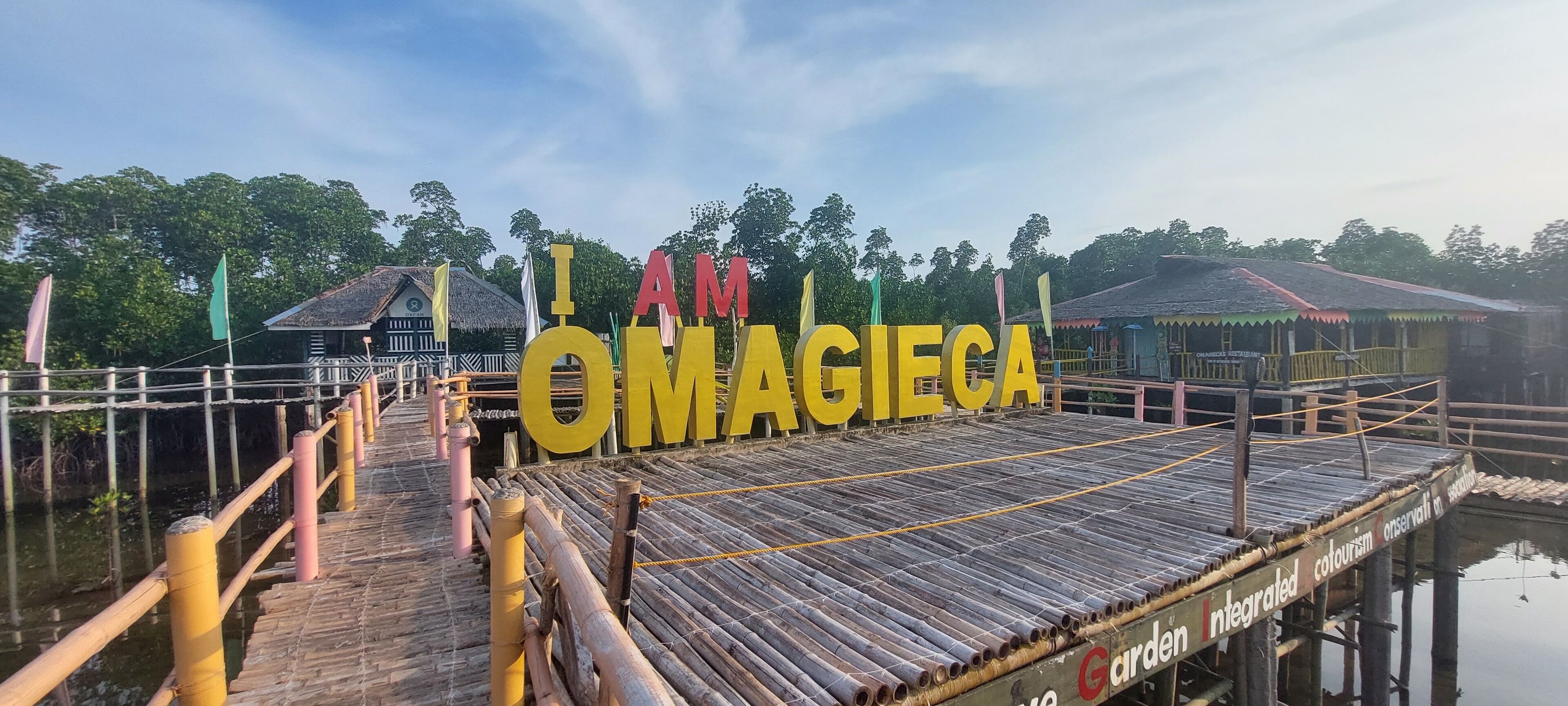 A wooden pier with a sign that reads "I AM OMAGIECA".