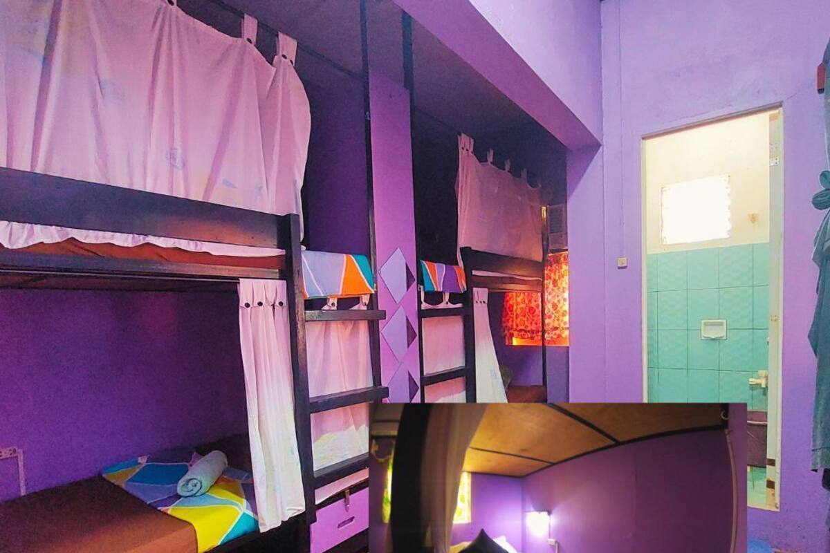 A room with bunk beds, a door, and a window.