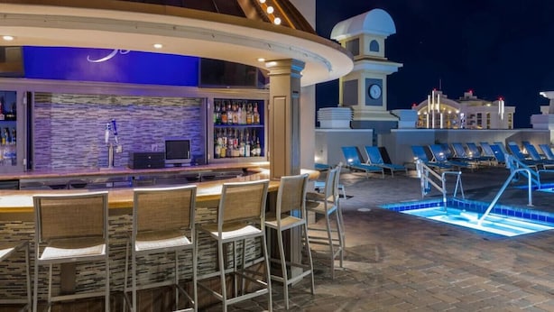 Un espace bar extérieur avec une piscine et des chaises longues.