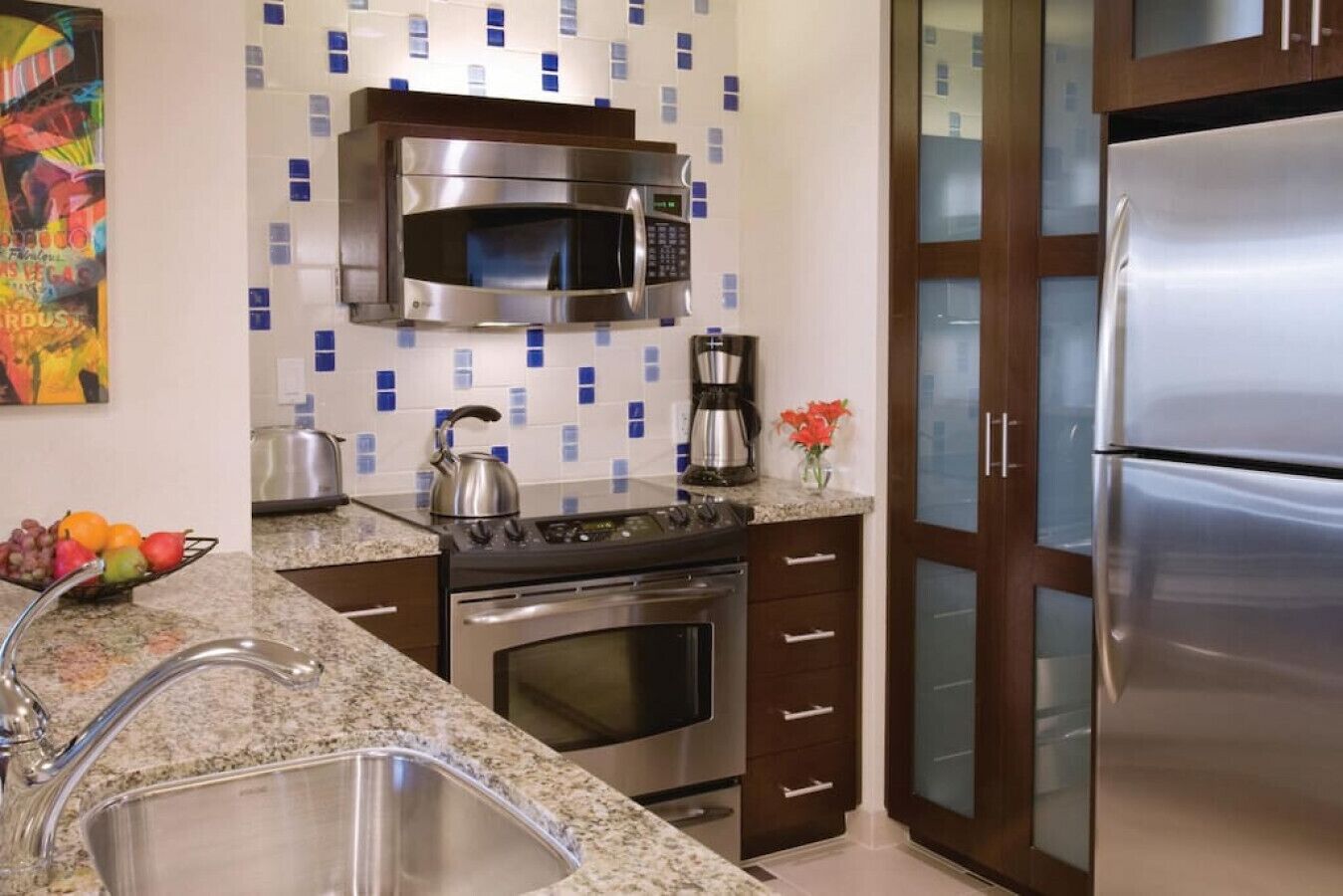 A modern kitchen with a stainless steel microwave, stove, oven, and refrigerator.