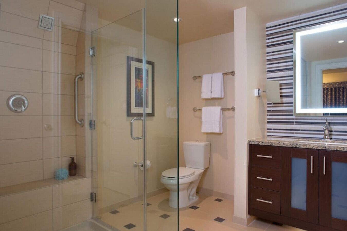 Ein modernes Badezimmer mit Glasdusche, Toilette und Waschtisch mit Spiegel.