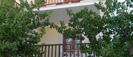 Un edificio a due piani con un balcone e una finestra.