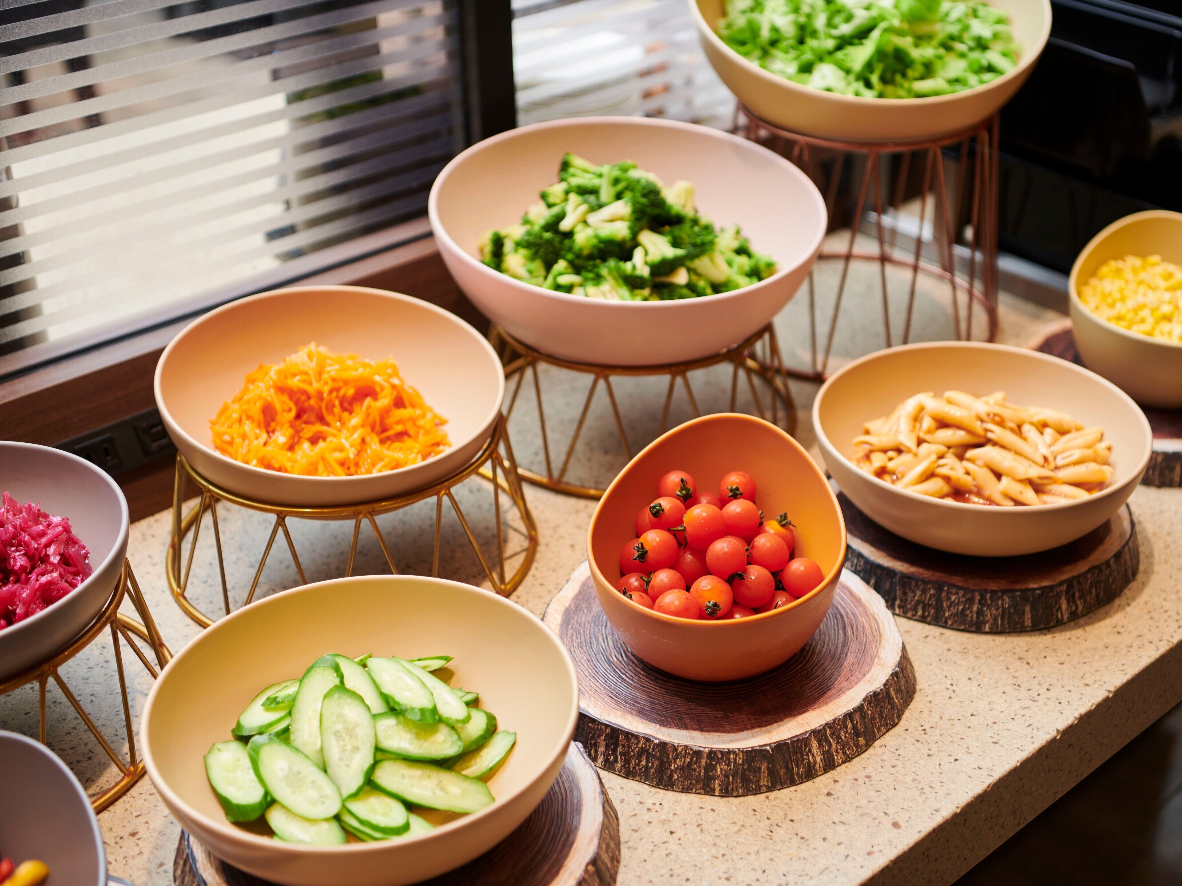 A variety of food bowls on a countertop with a window in the background.