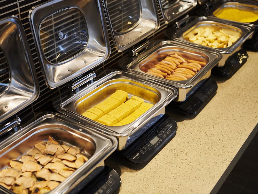 A buffet with various food items in metal containers.