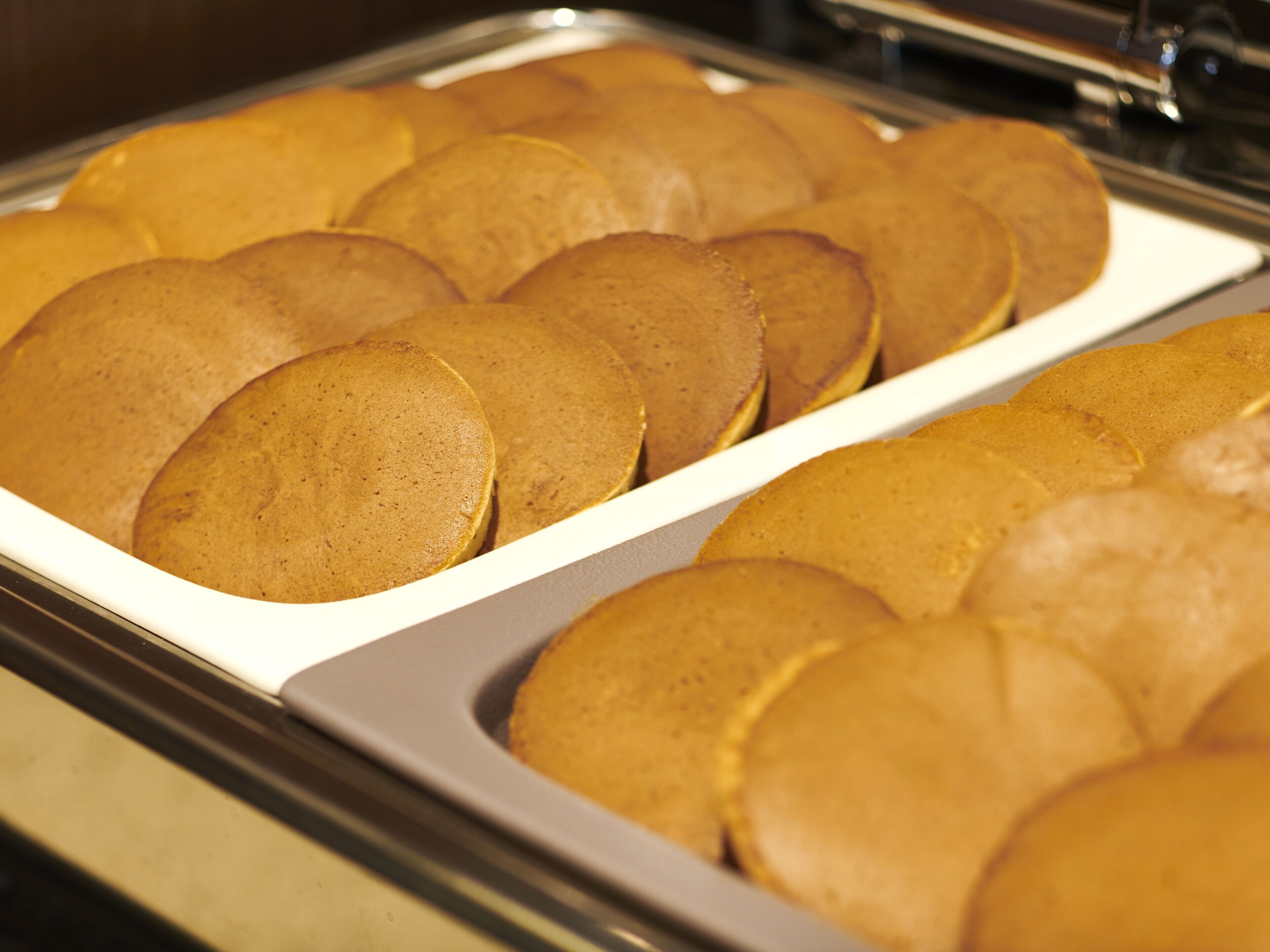 A tray of round, golden-brown pancakes.