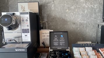 A coffee machine, a coffee menu, and a display of coffee pods.