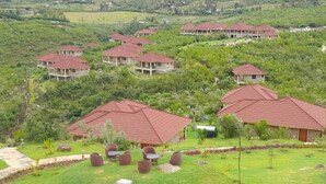 A cluster of red-roofed buildings surrounded by lush greenery, with a well-maintained lawn and outdoor seating area.