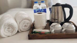 A neatly arranged tray with towels, toiletries, and a coffee maker on a hotel bed. - Patong Bay Inn (Patong)