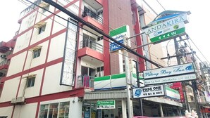 A multi-story building with a FamilyMart convenience store on the ground floor, a Patong Bay Inn sign, and a Pass One Phuket Tour Lounge sign. - Patong Bay Inn (Patong)