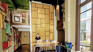 Un hall d’hôtel comprenant un comptoir d’accueil, un espace de stockage des bagages, un canapé et une grande fenêtre.