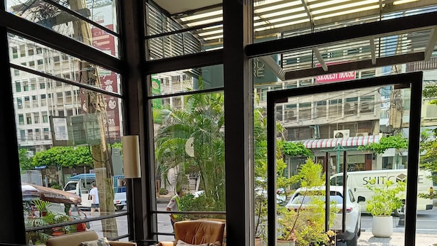 Un intérieur moderne avec un coin salon, un ordinateur portable et un smartphone posés sur une table.