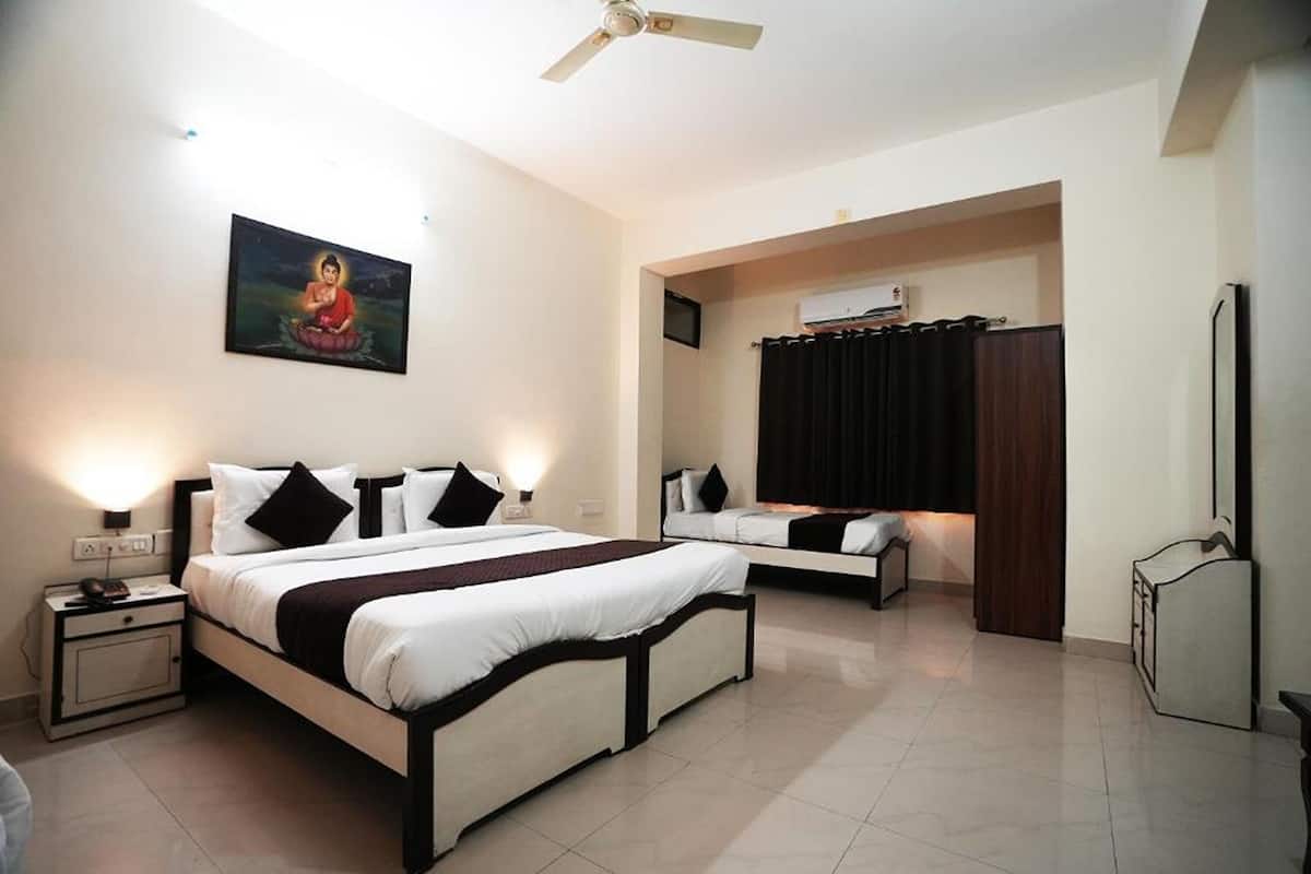 A hotel room with two beds, a ceiling fan, a painting on the wall, and a TV on the wall.