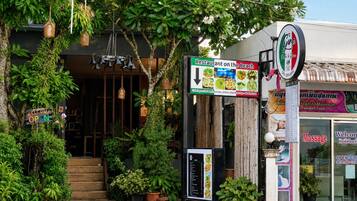 Un restaurante con un letrero que indica que está abierto, una pizarra de menú y un anuncio de servicios de masajes.