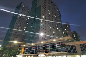 A modern building with multiple floors and illuminated windows.