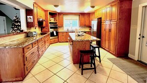 A spacious kitchen with wooden cabinets, a large island, and a built-in oven.