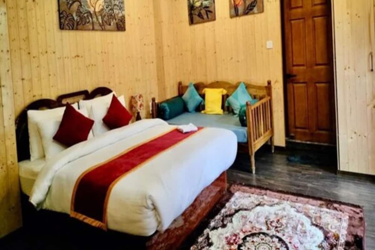 A wooden-paneled bedroom with a bed, pillows, and a rug.