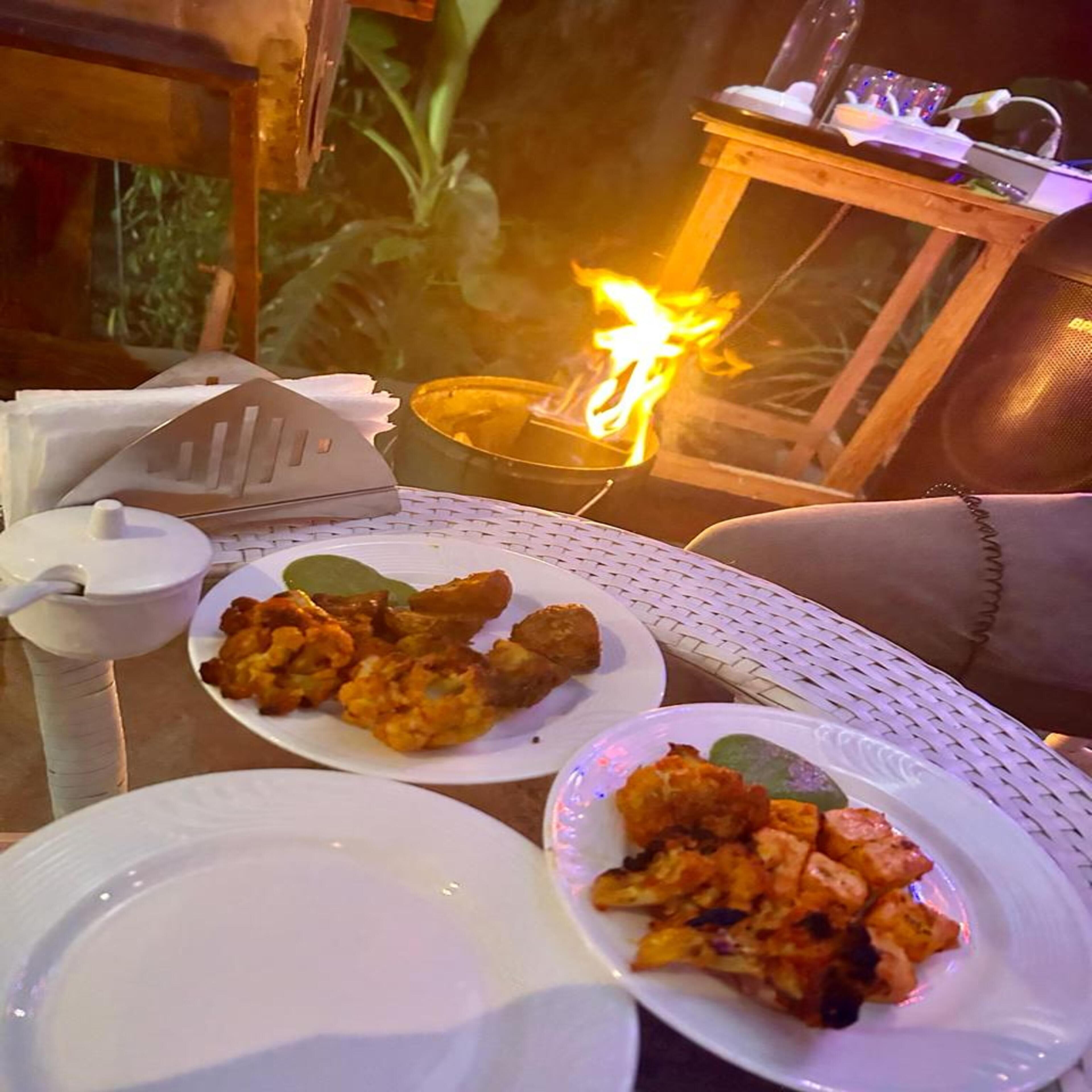A table set with plates of food, a candle, and a small table with a candle.