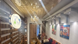 Un hall d’hôtel comprenant un comptoir d’accueil, un espace salon et un escalier.