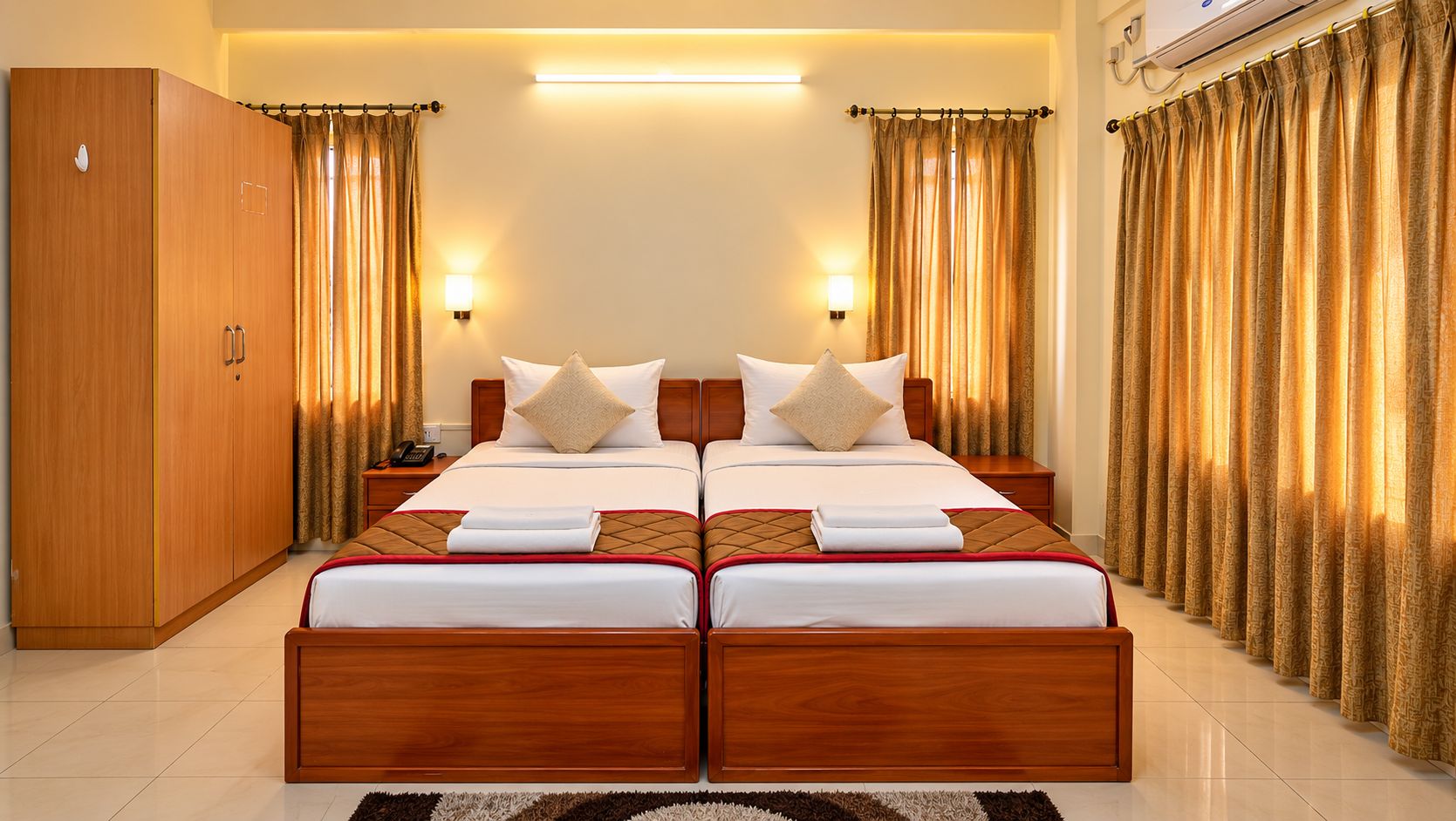A double bed with a wooden frame, two bedside tables, and a nightstand with a lamp.