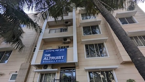 A multi-story building with a sign for "The Altruist Business Stays". - The Altruist Bellandur ORR Hotel (Bengaluru)