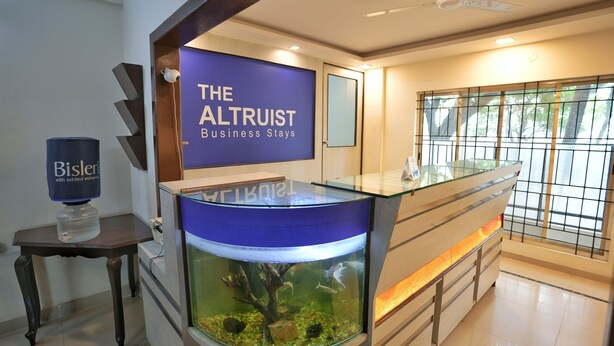 A reception area with a large aquarium, a sign reading 'The Altruist Business Stays,' and a water dispenser. - The Altruist Bellandur ORR Hotel (Bengaluru)