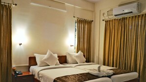 A double bed with white bedding, a wooden headboard, and a bedside table with a phone. - The Altruist Bellandur ORR Hotel (Bengaluru)