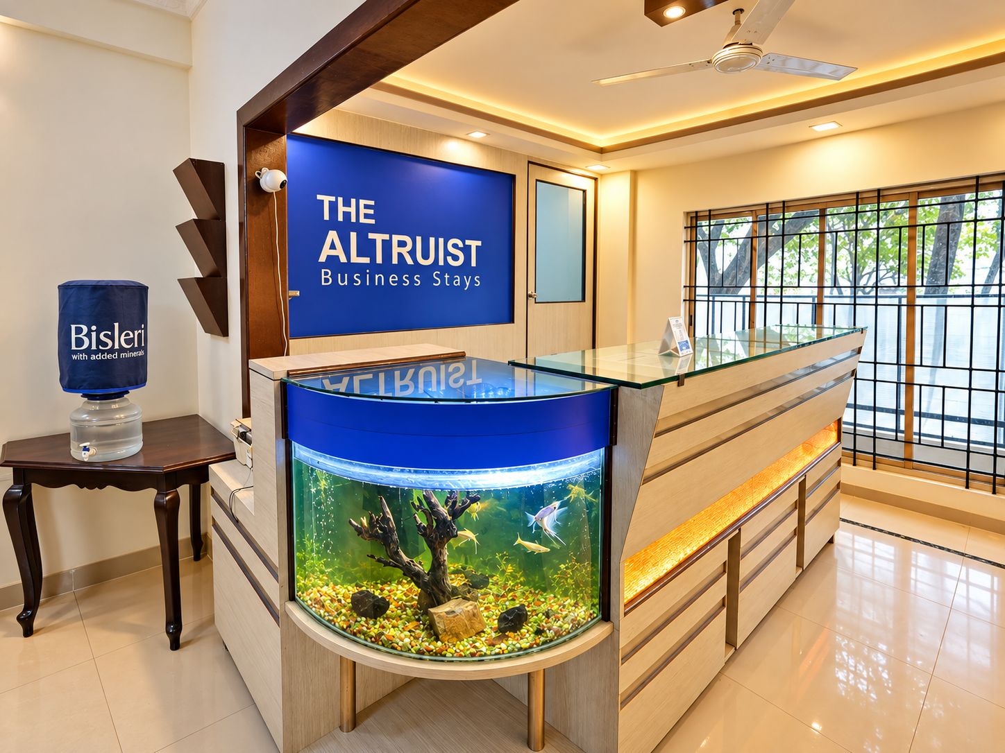 A reception area with a large aquarium, a reception desk, and a sign for 'The Altrust Business Stays.'
