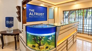 A reception area with a large aquarium, a reception desk, and a sign for 'The Altrust Business Stays.'