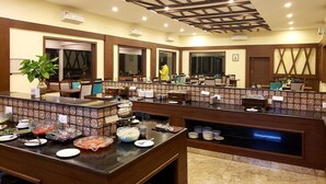 Un espace de restauration d’hôtel doté de plusieurs buffets, de lambris en bois et de luminaires au plafond.