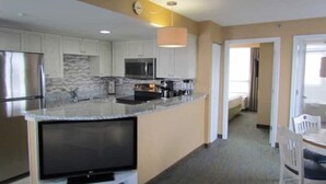 A modern kitchen with a large island, built-in appliances, and a flat-screen TV. - Studio unit at Boardwalk Villas  (Virginia Beach)