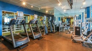 A gym with treadmills, weight machines, and mirrors on the walls. - Studio unit at Boardwalk Villas  (Virginia Beach)